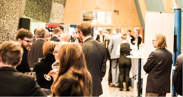 Business people at a conference, standing in groups and talking.